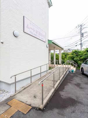 白壁の建物と駐車場エントランス