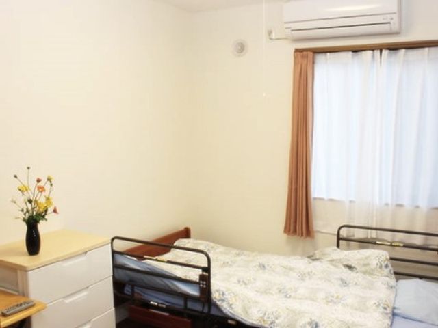 快適な居室の一角 居室 すっきりとした居室で、手元には花が飾られ、安らぎの時間を提供しています。くつろぎのひとときに最適な環境が整っております。