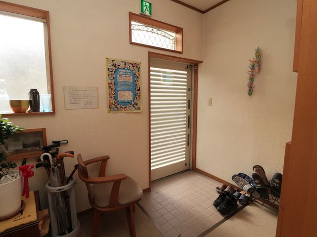 エントランスの穏やかな風景 玄関 暖かな光が差し込む落ち着いたエントランスです。来訪者が安らぎを感じられる、心地よい待合スペースが整っています。