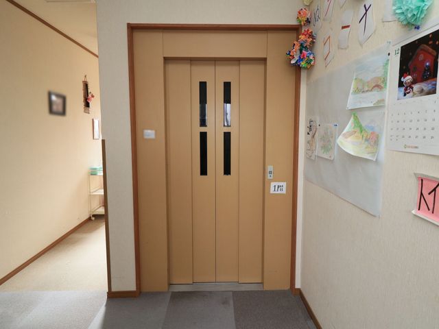 和やかなエレベーター前 エレベーター エレベーター前には手作りの飾りや掲示物があり、訪れる方々に温かい印象を与えています。空間は明るく清潔で、安心して利用できる環境です。