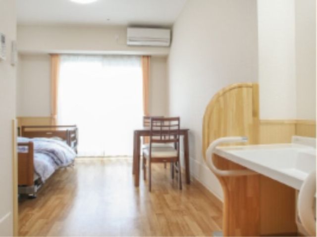 居室の明るい空間 居室 ゆったりとした居室は自然光が差し込み、清潔感があふれています。ベッドやテーブルも配置され、快適な日々を過ごせる環境が整っています。