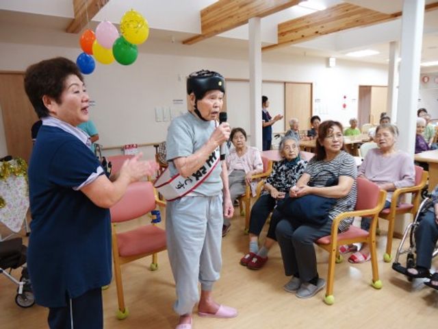 イベント中の多目的室 共有スペース 笑顔があふれる共有空間で、スタッフと利用者様がイベントを楽しんでいます。ここでは皆で歌をうたったり、ゲームをしたりして日々の生活に潤いを与えています。