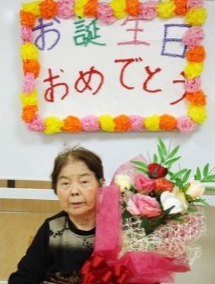 お祝いの花と笑顔の方