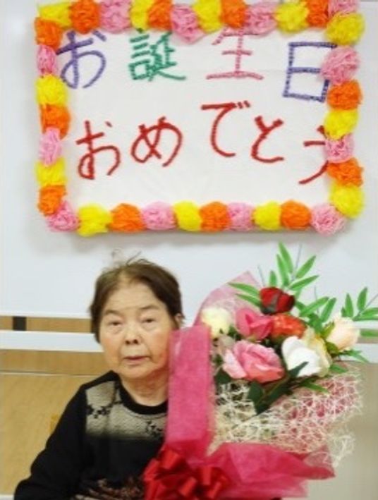 お祝いの花と笑顔の方