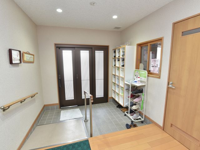 清潔感あるエントランス 玄関 明るく広々としたエントランスは、来訪者を温かく迎えます。手すりも設置され、より安心してご利用いただける環境です。