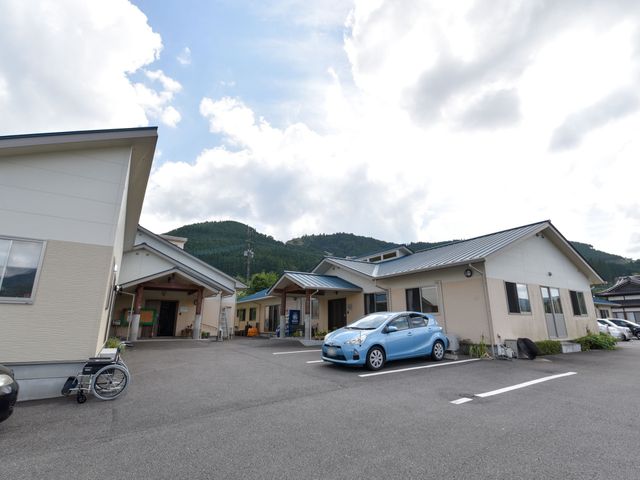 広々とした外観 外観 ゆとりある駐車場を備えた明るい建物が迎える雰囲気を演出しております。自然に囲まれた開放的な環境で、新しい職場を見つけませんか？