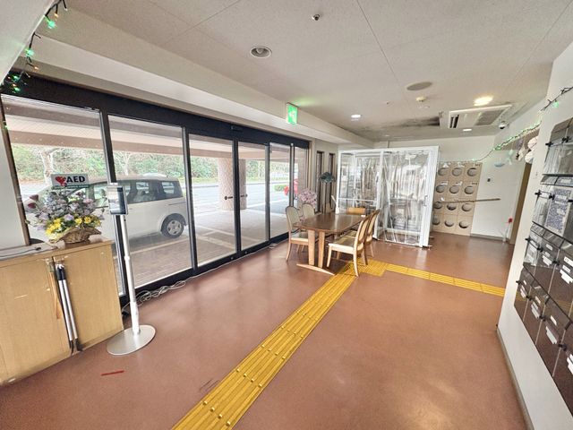 広々としたエントランス エントランス ガラス戸から自然光が差し込む開放的な空間です。店舗用のテーブルと椅子が備わっています。