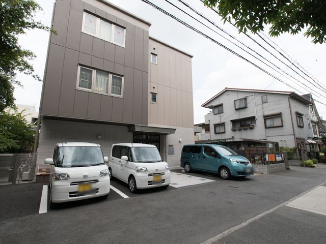 現代的な建物の外観 外観 落ち着いた色合いの建物が、周囲の街並みに溶け込んでいます。車両が停まるスペースも確保されており、便利な立地です。