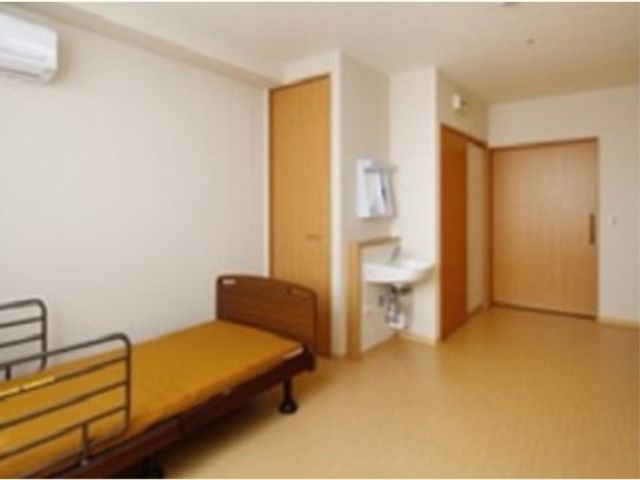 ベッドと洗面台のある居室 居室 明るく清潔感のある空間で、快適な日々を過ごすことができます。安全を配慮したベッド周りも備え付けられています。