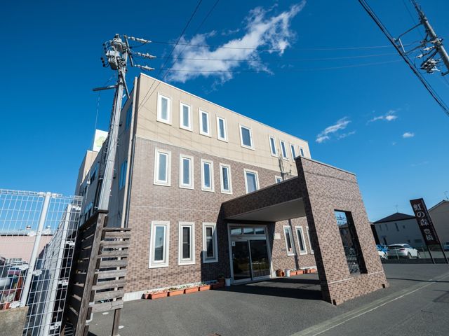 清潔な施設のエントランス 外観 広々としたエントランスは天気の良い日には陽光が差し込み、明るく開放的な雰囲気を創出しています。働く環境の第一印象として、訪れる方々を温かく迎え入れる設計になっています。