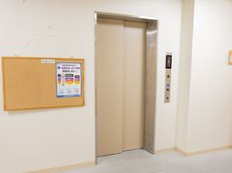 廊下のエレベーターと掲示板