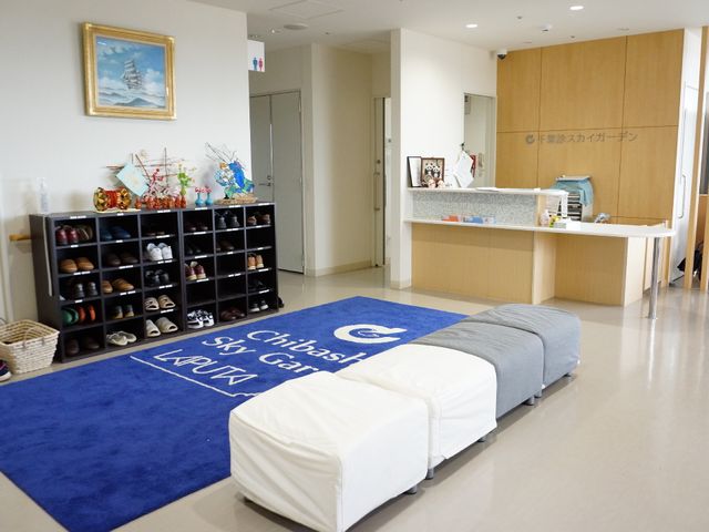 明るいエントランス風景 靴箱 素敵なアートと清潔な受付がお出迎え。ここから新しい職場へ一歩を踏み出しませんか。