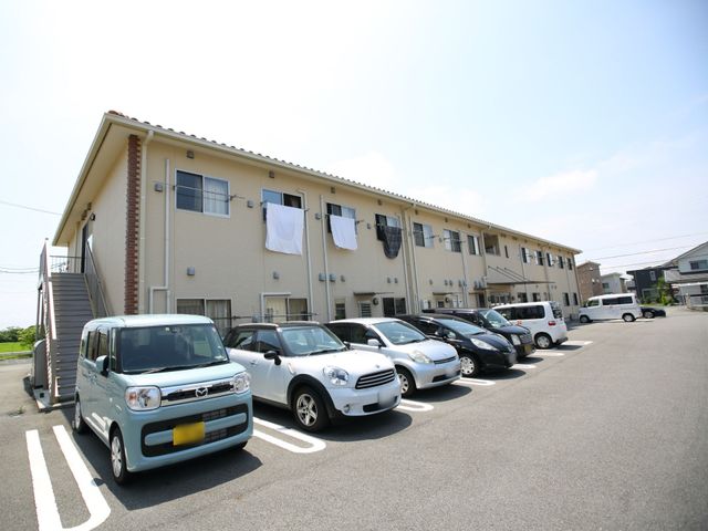広々とした駐車場のある建物 外観 ゆとりの駐車スペースがある快適な職場です。明るく広々した環境でのびのびとお仕事できます。