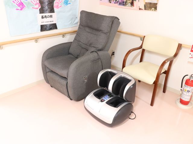 リラクゼーションコーナー マッサージ器 ゆったりとくつろげるリクライニングチェアとフットマッサージャーを完備した休憩スペースです。日々の疲れを癒すひと時を提供します。