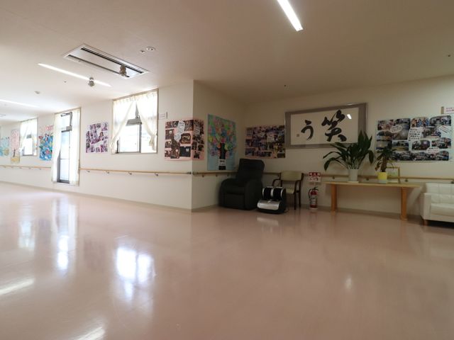 ゆったりとした共有スペース 廊下 明るいライトが照らす広々とした共有エリアです。壁に飾られたアートや写真が、訪れた人々に温かい雰囲気を提供しています。