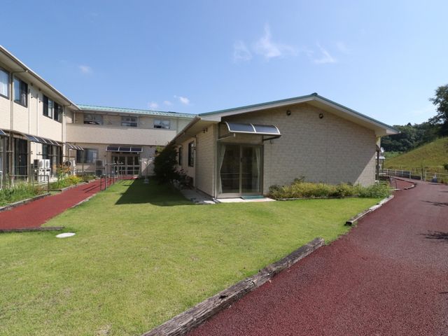 緑豊かな施設外観 外観 緑に囲まれた爽やかな建物が、日々の快適な勤務環境を提供します。自然光あふれる設計で、明るい雰囲気の中でのお仕事が可能です。