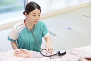 看護師が腕を診察する様子