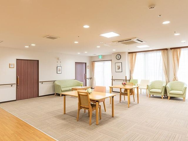 共有スペースの明るい居室 談話室 ゆったりくつろげるラウンジは、日差しを浴びながら心地よい時間を過ごせる空間です。落ち着いた色合いが、安らぎを提供しています。