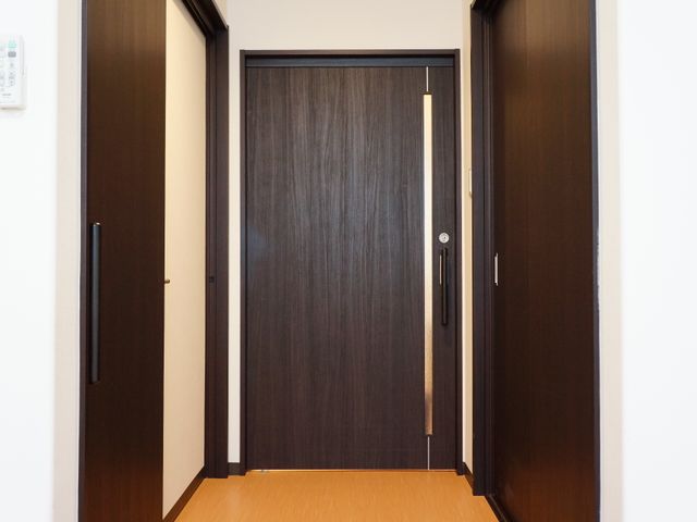 茶色の洋室ドア 個室入り口 手が届きやすい位置に取っ手が設置された居室のドアです。洗練されたデザインが特長で、落ち着いた雰囲気を醸し出しています。