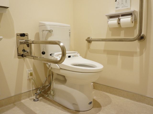 バリアフリー設計のトイレ 手すり付きトイレ 手すりがついた安全に配慮されたトイレです。使いやすさを考え、ゆとりある空間が整っており、安心してお使いいただける環境を提供しています。