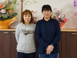 スタッフ二人と背景の花