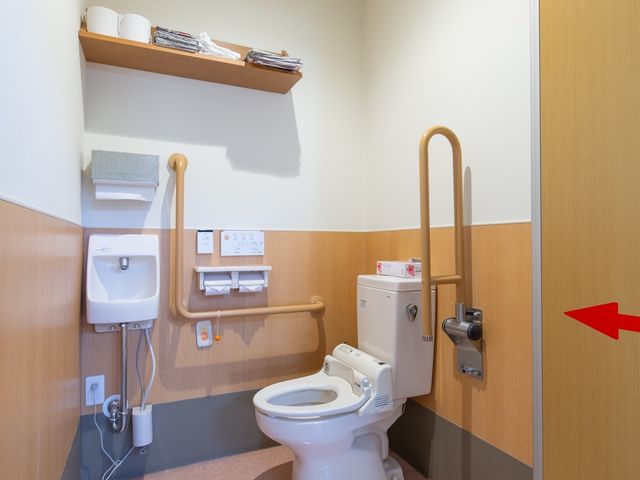 バリアフリー設計のトイレ トイレ 手すりのついた安全なトイレです。清潔感が保たれた環境で、ご利用者様の快適性が考慮されています。