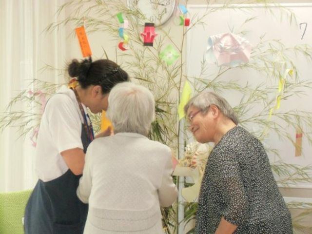 笑顔で会話する三人 談話室 明るい空間で楽しそうに交流しており、心温まる光景です。