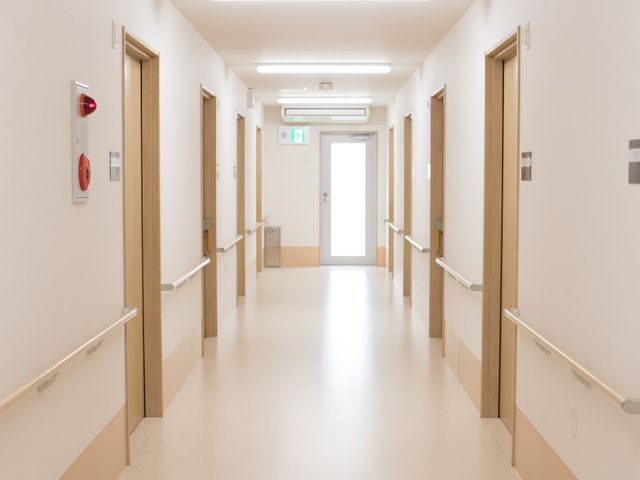 清潔感のある明るい廊下 廊下 手すり付きで広々とした廊下は、利用者の安全な移動をサポートしております。壁面の落ち着いた色合いが穏やかな雰囲気を醸し出しています。