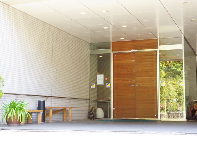 入り口と掲示物の配置 入り口 清潔感のあふれるエントランスに、役立つ情報が掲示されております。ベンチが設けられていて、外出前のひとときも快適です。