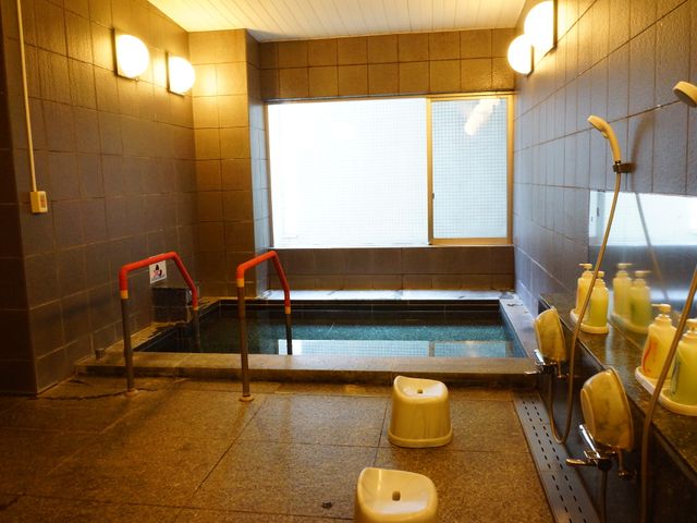 ゆったりした浴室の一角 風呂場 手すり付きで安心の浴室は、温もりを感じるバスタイムを提供します。窓からの自然光が入り込む、明るい空間です。