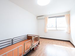 明るい居室のベッドと窓