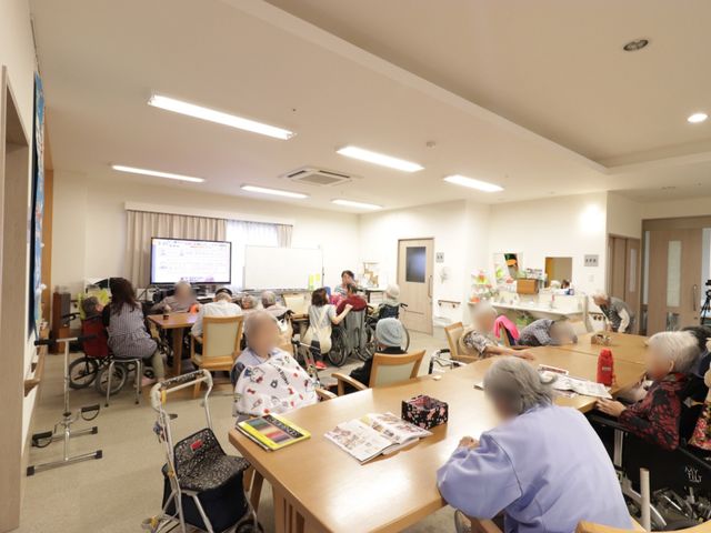 多目的室での憩いの時 食堂 広々とした明るい多目的室では、利用者が集い、社交的な活動やリラクゼーションのひと時を過ごされています。