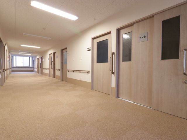 清潔感のある明るい廊下 通路 手すりが整備された清潔感のあふれる廊下です。広々としたスペースで、快適な移動が行える環境が整っています。