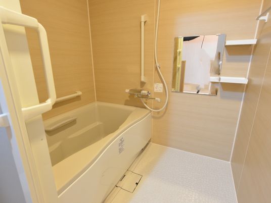 サーモスタット混合栓シャワー付きのお風呂場となっている。浴槽周辺に手すりが設置してあり、入浴を補助する。