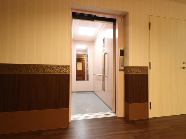 エレベーターの入り口 エレベーター前 明るい照明の下、清潔感のあふれるエレベーター前が広がっています。