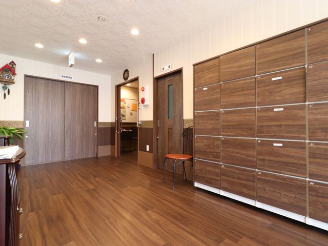 明るく清潔な廊下の様子 ドアと床 清潔感のあふれる木目調の廊下で、落ち着いた空間が広がっています。