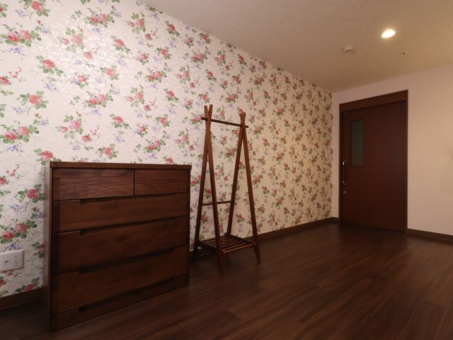 花柄壁紙の居室空間 居室 落ち着いた雰囲気のある部屋です。収納家具も完備されております。