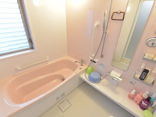 ライトピンクを基調とした明るく広々とした浴室である。窓からの光が差し込みリラックスできる空間になっている。