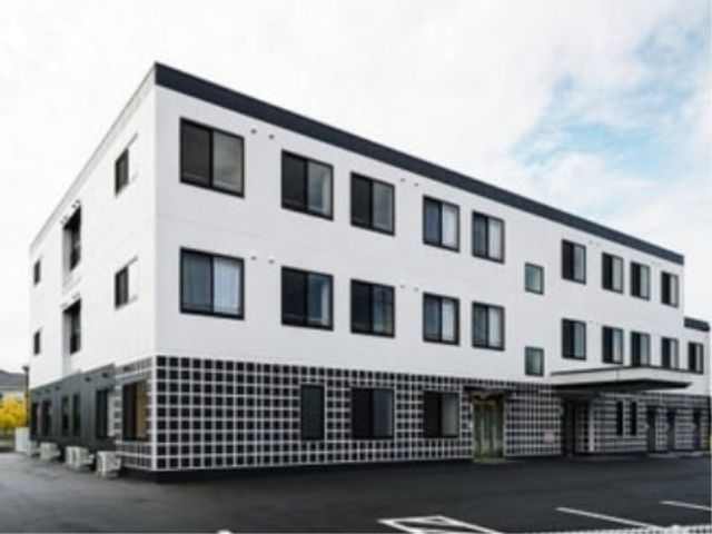 白い建物外観イメージ 外観 モダンなデザインの建物外観は、清潔感があり、広々とした駐車スペースが整備されています。快適な勤務環境をお求めの方にはぴったりです。
