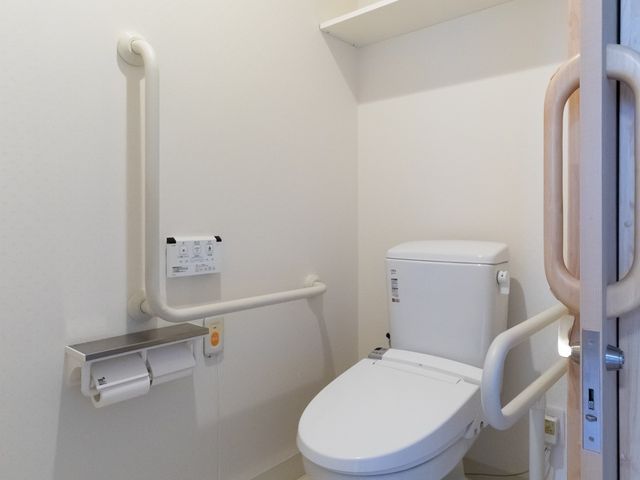 バリアフリー設計のトイレ トイレ 手すりが設置された安全なトイレ空間。すべての方が安心してご利用いただける設計です。
