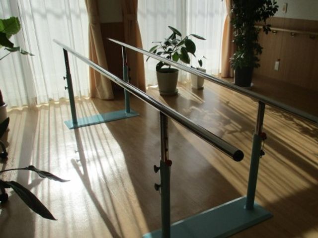 明るい室内の歩行訓練器具 リハビリ 日差しが心地よい部屋で行われる歩行訓練は、ご利用者さまの健康維持に貢献します。