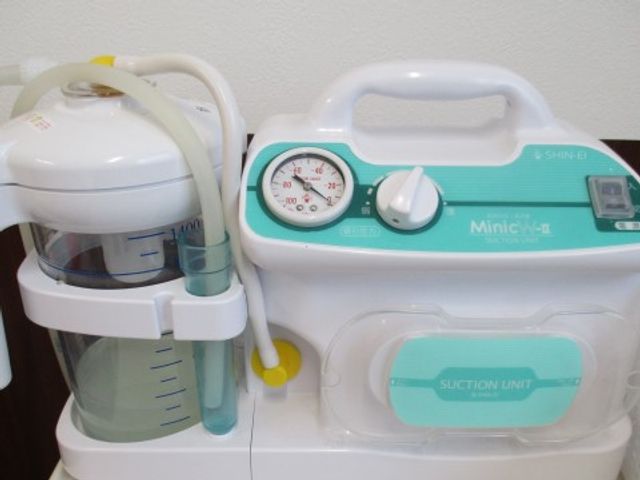 医療機器のクローズアップ 吸引器 清潔感のある医療機器が備え付けられ、充実した設備でケアを提供しています。患者様の健康維持をサポートする環境です。