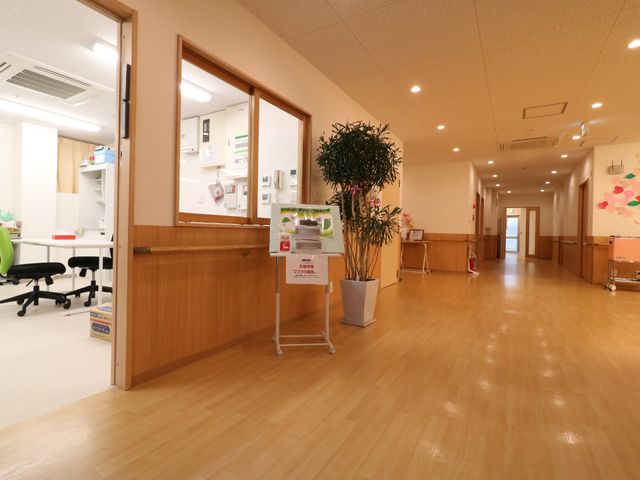 明るく広い廊下 広くて開放的な廊下 広々として清潔感のある廊下は、快適な動線を提供します。スタッフの動きも活発で、明るい職場環境が伺えます。