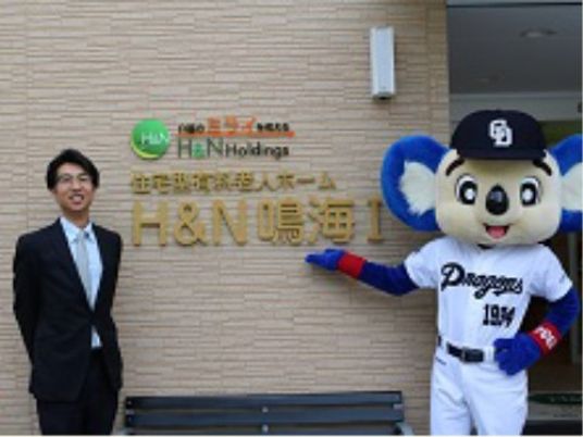 笑顔で立つ人とキャラクター