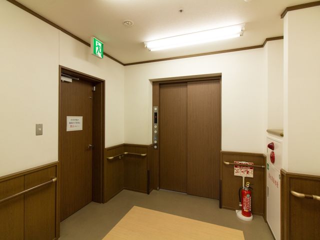 廊下の扉とエレベーター エレベーター 清潔感があり、バリアフリー設計に配慮された廊下です。広々としており、快適な移動が可能です。