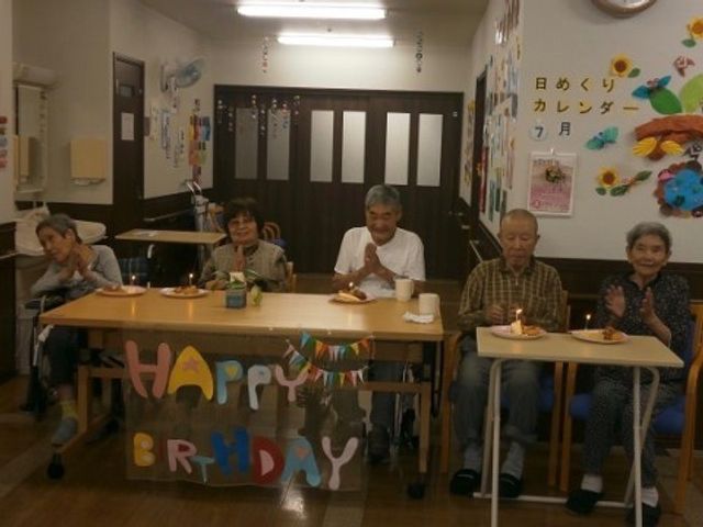 誕生日祝いの食堂風景 お誕生日２ 温かな雰囲気に包まれた食堂で、一緒にお祝いの時間を過ごす様子が伝わります。対面でコミュニケーションを取りながら、楽しいひとときをお過ごしいただける空間です。