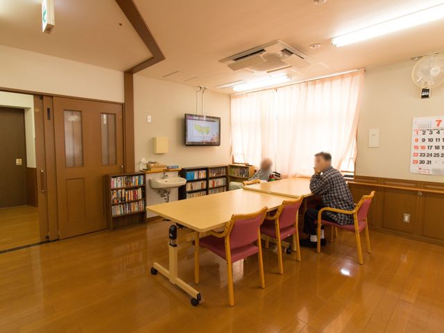 共有スペースと本棚 談話室 明るいラウンジでは、本を読むのも良し、テレビを観るのも良しのゆったりした時間が過ごせます。適度なプライバシーを確保しながら、様々な娯楽を楽しむことができます。
