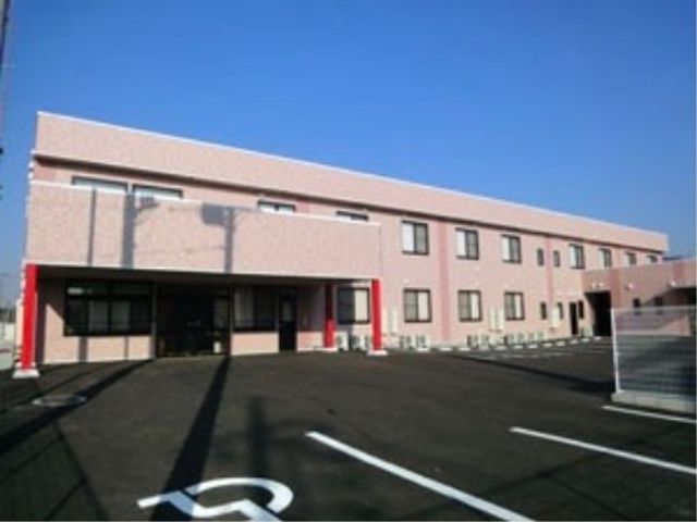 ピンクの壁の建物外観 施設外観 広々とした駐車スペースがある、ピンク色の外壁が特徴の建物です。清潔感のあふれる環境でお仕事しませんか。