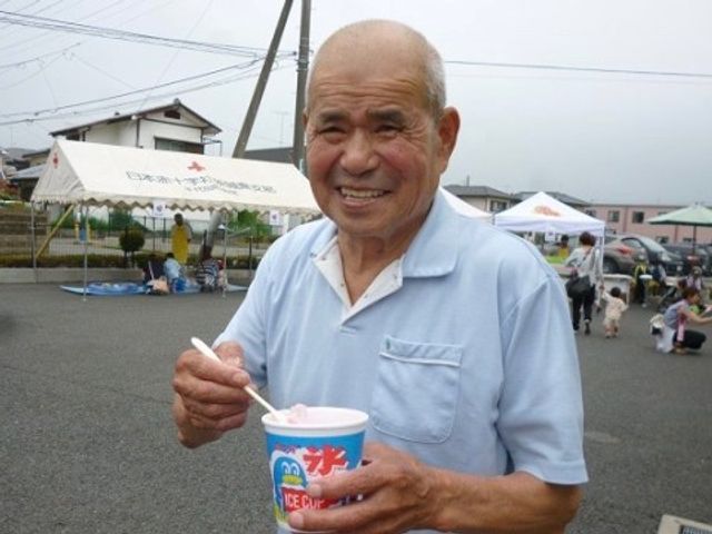楽しそうな高齢者男性 バーベキュー アイスクリームを手に笑顔の男性が、外での時間を楽しんでいる様子です。穏やかな雰囲気が感じられ、充実した日々を過ごせそうです。