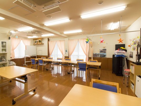 広い空間の食堂兼共有スペースは、窓が多くあり窓際に長方形のテーブルと椅子が置かれている。天井には空調がある。